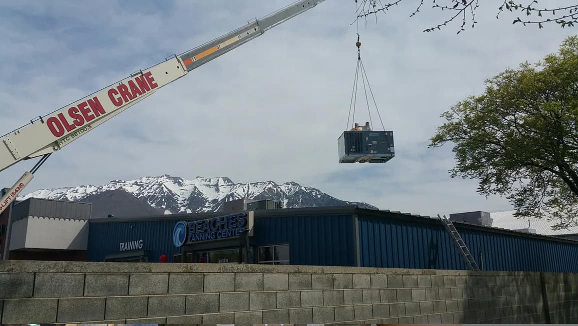 Crane lifting rooftop unit